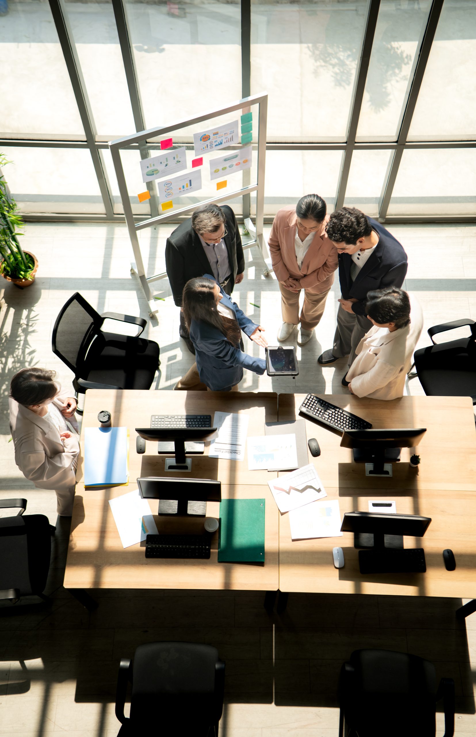 Multicultural business team standing around a desk and reviewing